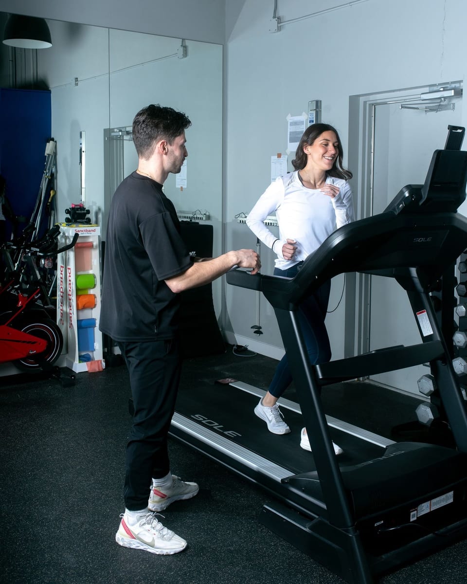 A therapist supervising a client on the treadmill during return to sport testing